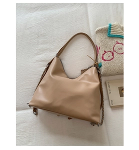 Detail of khaki leather shoulder bag with chic silver chain and soft texture