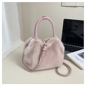 Detail of soft pink faux fur handbag with adjustable leather strap and metal buckle