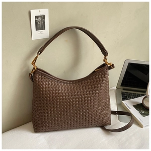 Detail of dark brown woven texture on hobo shoulder bag with gold hardware accents