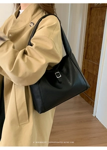 Chic black crescent underarm bag with silver buckle worn by a model in a minimalist style