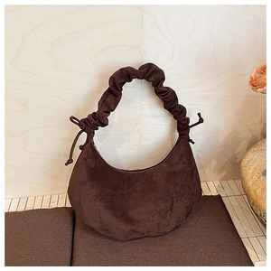 Close-up of vintage dark brown faux suede dumpling bag with pleated handle and drawstring detail