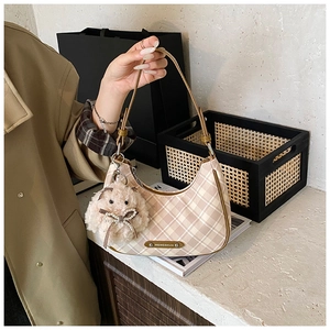 Detail shot of beige plaid shoulder bag featuring a cute white bunny plush charm accessory