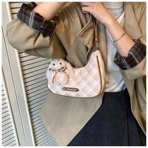 Close-up of pink checkered shoulder bag with a cute white plush bunny charm detail