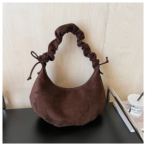 Detail of dark brown matte hobo bag with a pleated cloud-style handle and drawstring sides
