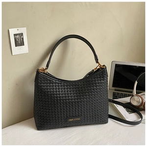 Close-up of black woven hobo bag with gold metal plate and detachable shoulder strap