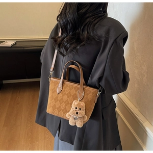 Détail du sac seau marron avec motifs gaufrés et pendentif ours en peluche mignon