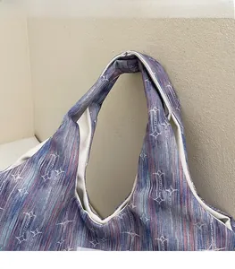 Detail of a tote bag featuring red and blue stripes with a white star pattern and wide strap