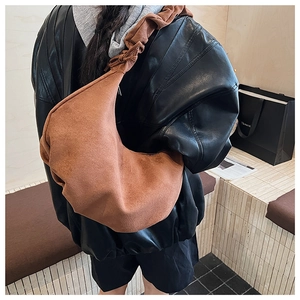Detail of brown suede crossbody bag with unique knotted strap and large capacity