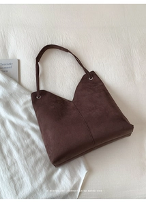 Detail einer minimalistischen dunkelbraunen Velours-Tragetasche mit V-Ausschnitt