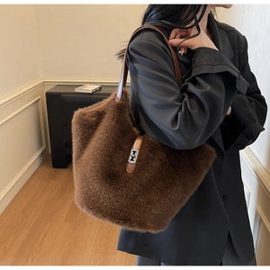 Close-up of brown faux fur tote bag with leather strap and silver metal twist lock