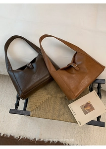 Detailed close-up of retro large-capacity tote bags with silver buckle on textured seat