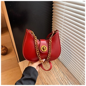 Dettaglio della borsa hobo rossa a mezzaluna con chiusura a scatto dorata e catena