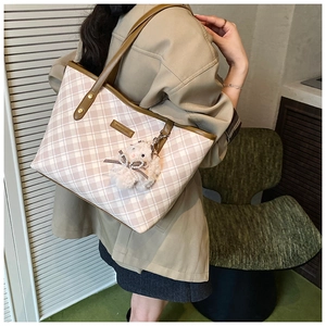 Close-up of pink and white checkered tote bag with leather straps and plush lamb charm