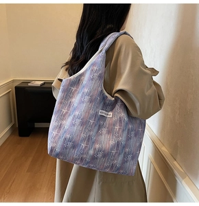 Close-up of a large tote bag featuring abstract purple star patterns and a woven label