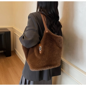 Detail of dark brown plush tote bag showing soft faux fur texture and silver metal clasp
