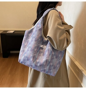 Detail view of large canvas tote bag featuring gradient purple print and star patterns