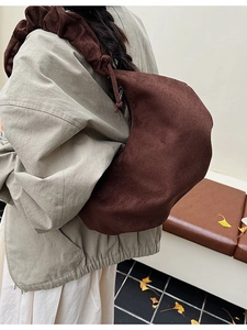 Vintage dark brown suede dumpling bag with pleated strap worn with an autumn trench coat