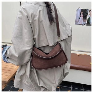 Sac hobo chic en daim marron porté avec un trench pour un style automnal élégant