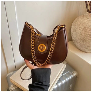 Dettaglio borsa a mezzaluna in pelle marrone scuro con catena dorata e fibbia in metallo