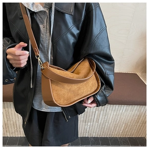 Détail du sac hobo en daim marron caramel avec bandoulière réglable et ferrures dorées