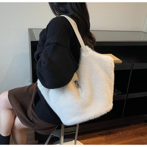 Detail of plush off-white tote bag showing dense faux fur texture and leather strap