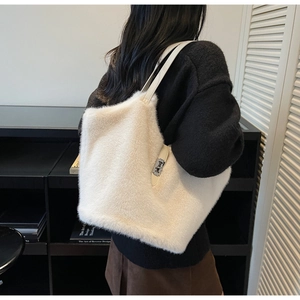 Detail of white faux fur tote bag with leather straps and silver metal lock closure