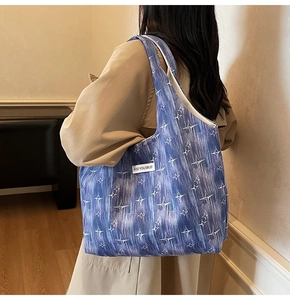 Detail of navy canvas tote bag with white star patterns and Kiss Yourself fabric label
