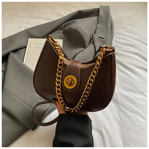 Dettaglio borsa hobo in pelle marrone con chiusura rotante dorata e catena vintage