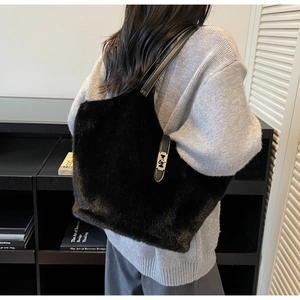 Detail view of large black plush faux fur tote bag with leather strap and metal clasp