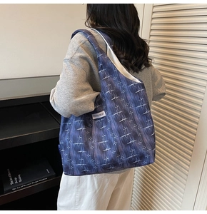 Detail view of blue star-patterned tote bag showing the Kiss Yourself label on the side