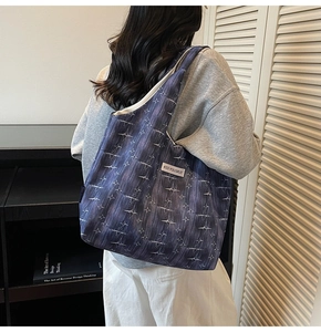 Detail of canvas tote bag with white star pattern and Kiss Yourself woven side label