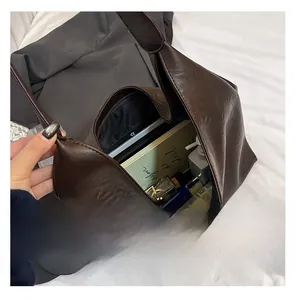 Interior view of large brown faux leather tote bag showing spacious storage for tablet and books