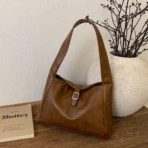 Nahaufnahme der braunen Hobo-Tasche mit genarbtem Kunstleder auf einer Holzoberfläche