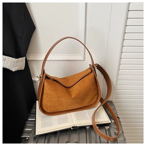 Vue détaillée du sac hobo en daim marron avec finitions en cuir lisse et bandoulières