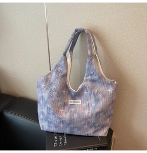 Detail of printed tote bag showing star patterns and woven texture on a sofa