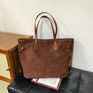 Detail showing brown suede leopard tote bag with leather straps and metal D-ring accents