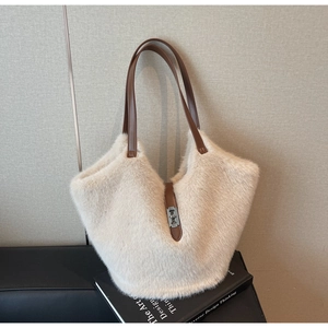 Detail of plush tote bag showing soft faux fur texture and brown leather handles