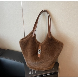 Detail of plush brown tote bag featuring soft faux fur texture and silver metal twist lock