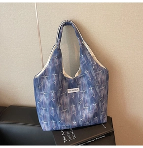 Close-up of blue hobo tote bag with star patterns and KISS YOURSELF woven label detail