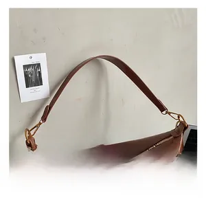 Dettaglio della borsa tote marrone lucida con cerniera in metallo e tracolla ampia