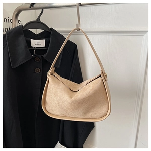 Vue détaillée du sac croissant en daim kaki avec finitions en cuir lisse et large poignée
