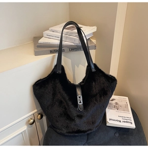 Chic black plush tote bag with silver metal clasp detail on an elegant background