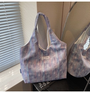 Detail of blue galaxy pattern tote bag featuring Kiss Yourself woven label and large capacity