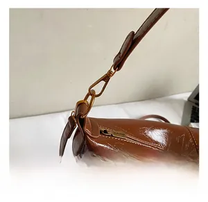 Dettaglio macro del gancio in metallo dorato e della trama della pelle cerata