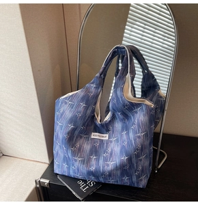 Detail of blue printed tote bag with white stars and Kiss YourSlef label on canvas