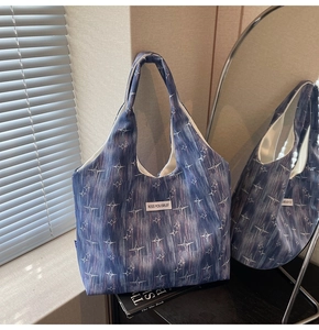 Detail of blue canvas tote bag featuring starburst patterns and Kiss Yourself label