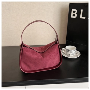 Détail du sac hobo en daim bordeaux avec finitions en cuir et anse élégante pour femme