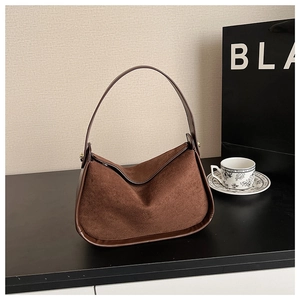 Detailed close-up of dark brown suede hobo bag with leather trim and fine stitching