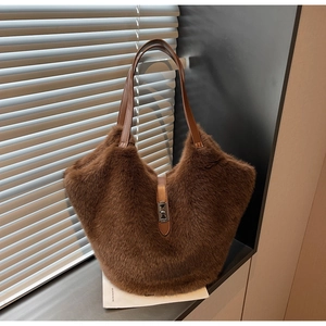 Detailed view of dark brown plush tote bag with silver twist lock and leather trim