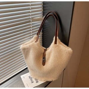Detail of plush tote bag with brown leather handles and metal twist lock closure